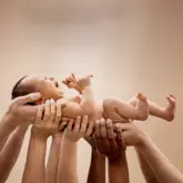 Baby wordt op handen gedragen